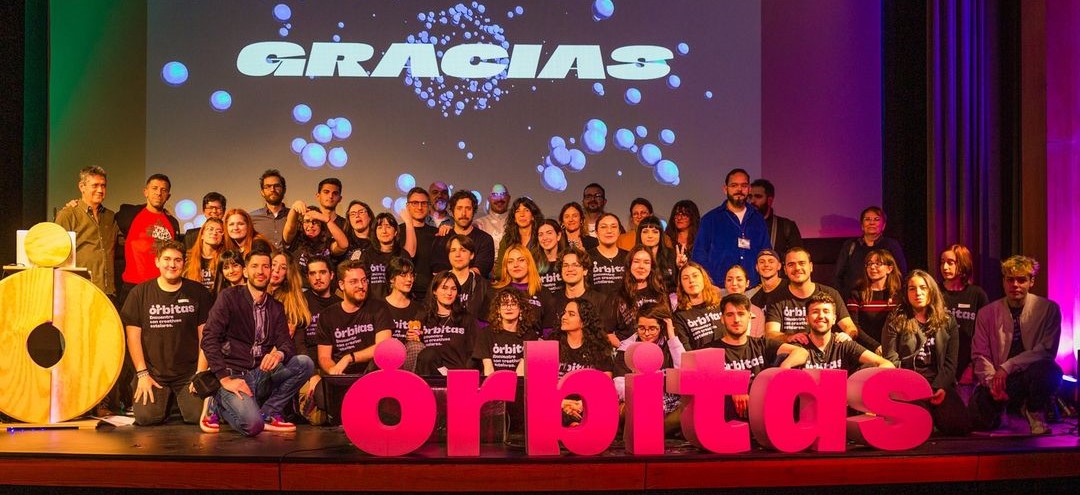 Foto de grupo de la anterior edición de Órbitas (2023) con los ponentes y staff sobre el escenario.